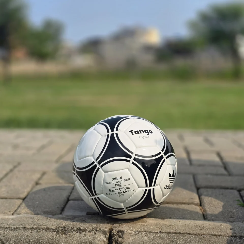 Black Circular Panel Hand-Stitched Football front view - white handmade football with black circular panel graphics and small printed details