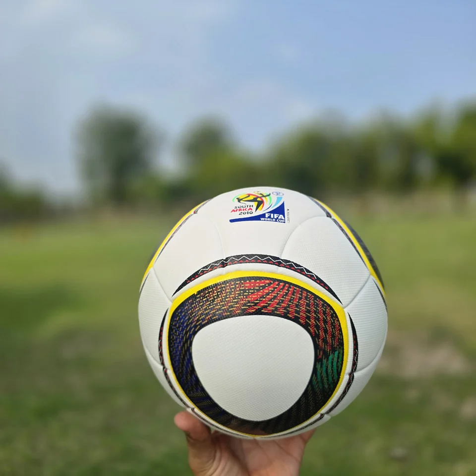 Black Gold Circular Panel Thermal Bonded Football alternate front angle - white thermal bonded football with black, gold, green, and red circular panel artwork