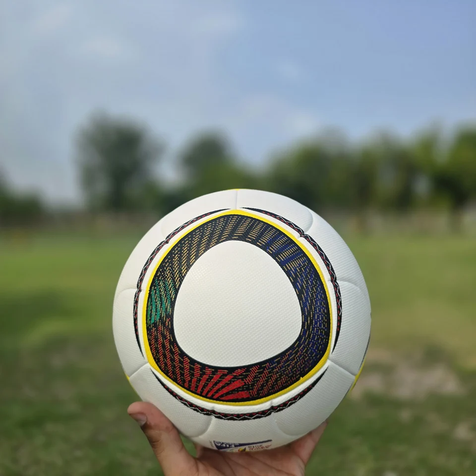 Black Gold Circular Panel Thermal Bonded Football side view - white thermal bonded football with black, gold, green, and red circular panel artwork