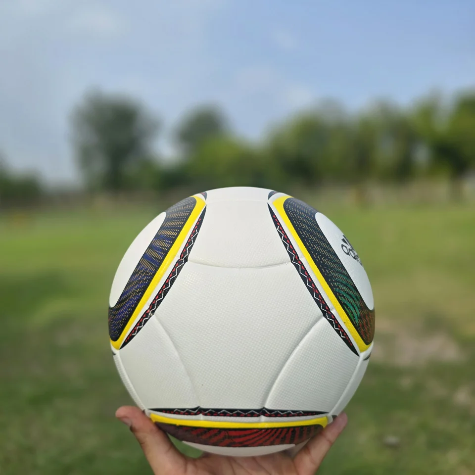 Black Gold Circular Panel Thermal Bonded Football side view - white thermal bonded football with black, gold, green, and red circular panel artwork