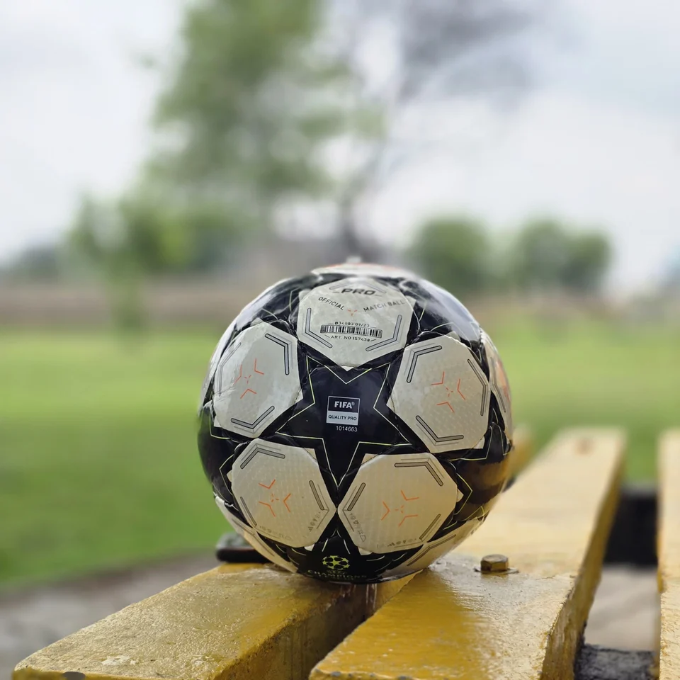 Black Star Graphic Hand-Stitched Football side view - black and white handmade football with star-shaped panels and a small green centre detail
