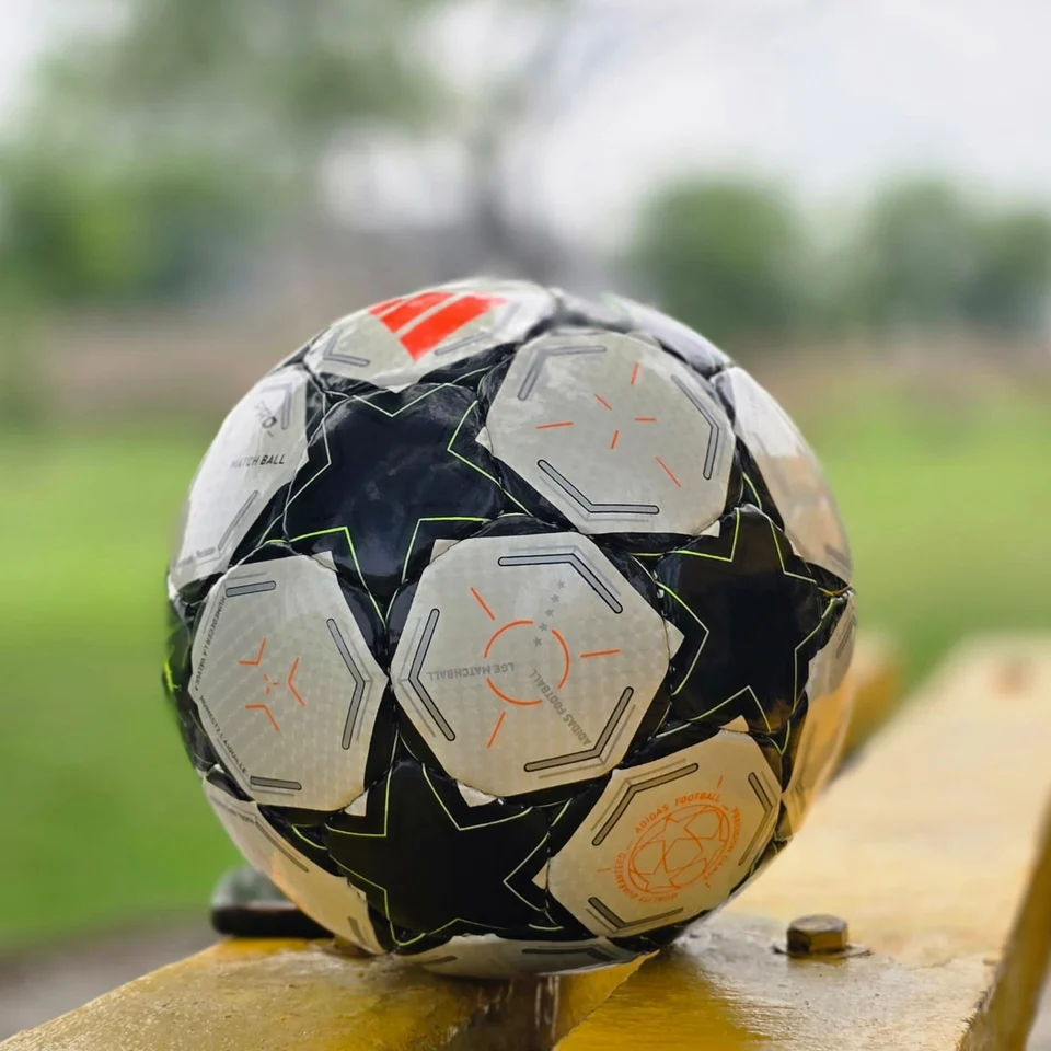 Black Star Graphic Hand-Stitched Football side view - black and white handmade football with star-shaped panels and a small green centre detail