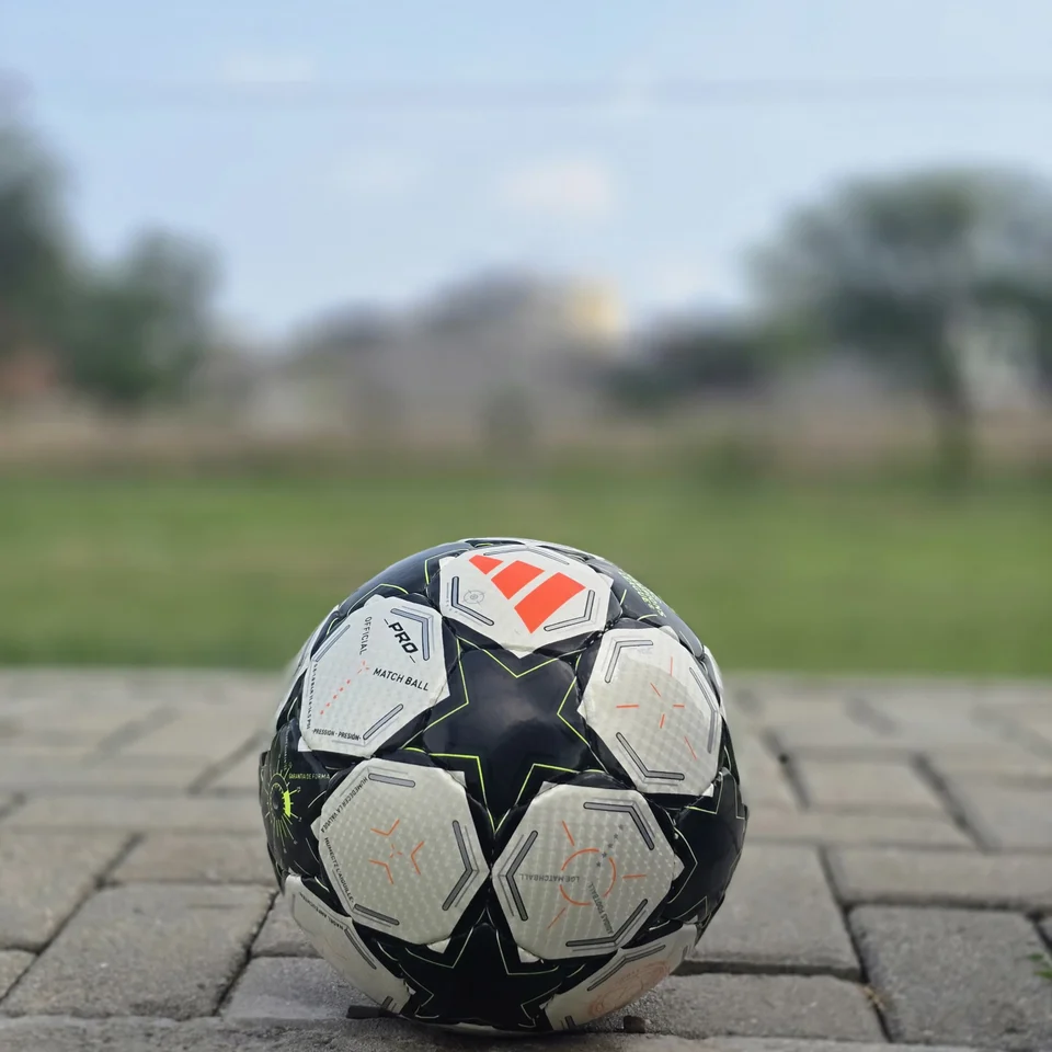 Black Star Panel Hand-Stitched Football front view - white and black handmade football with bold star-shaped panel artwork and a small red accent