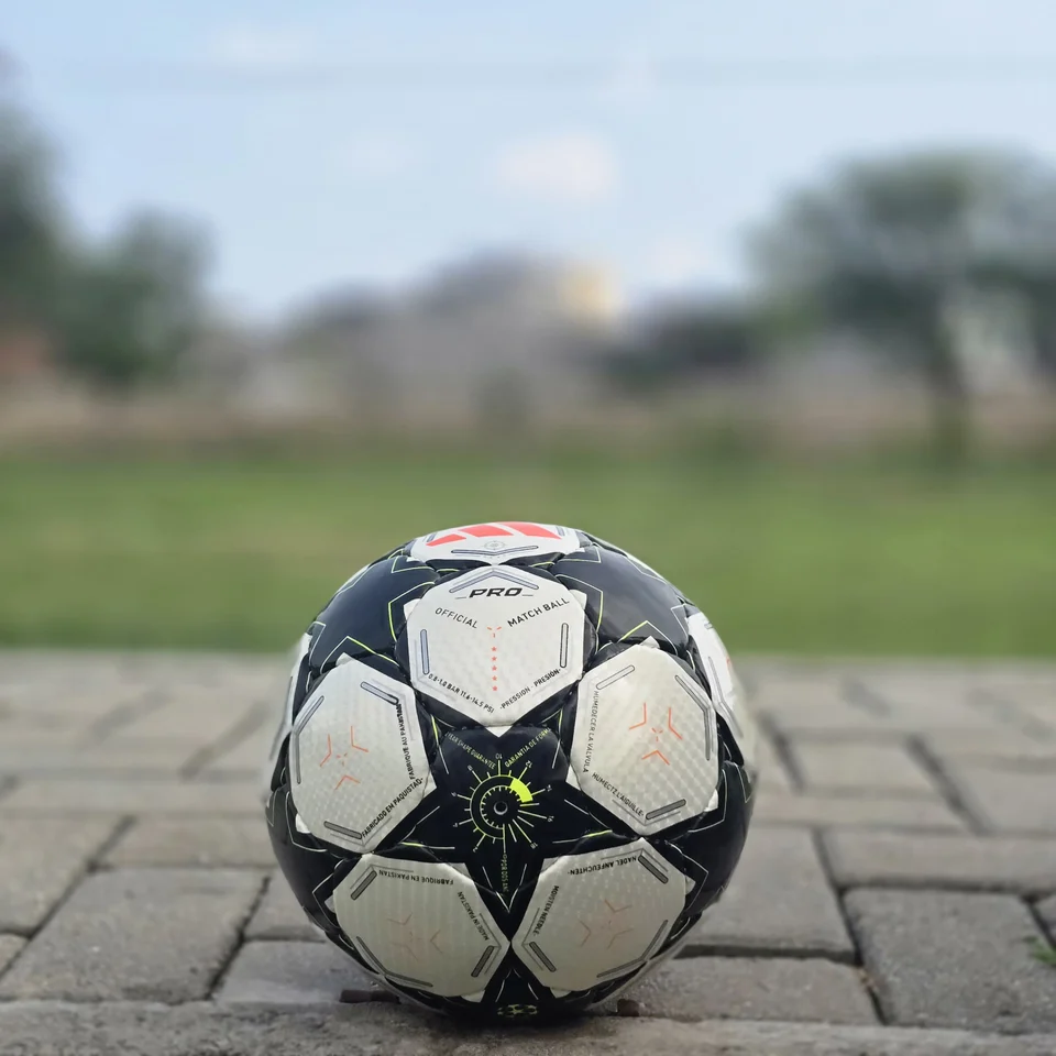Black Star Panel Hand-Stitched Football side view - white and black handmade football with bold star-shaped panel artwork and a small red accent