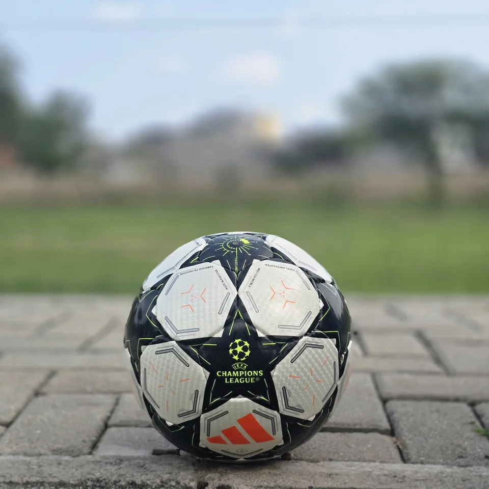 Black Star Panel Hand-Stitched Football side view - white and black handmade football with bold star-shaped panel artwork and a small red accent