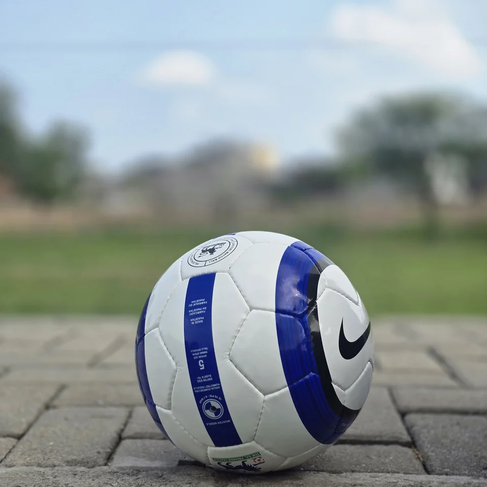 Blue Purple Tricolor-Style Hand-Stitched Football construction detail - white handmade football with blue and purple panel graphics and visible tricolor-style printed text