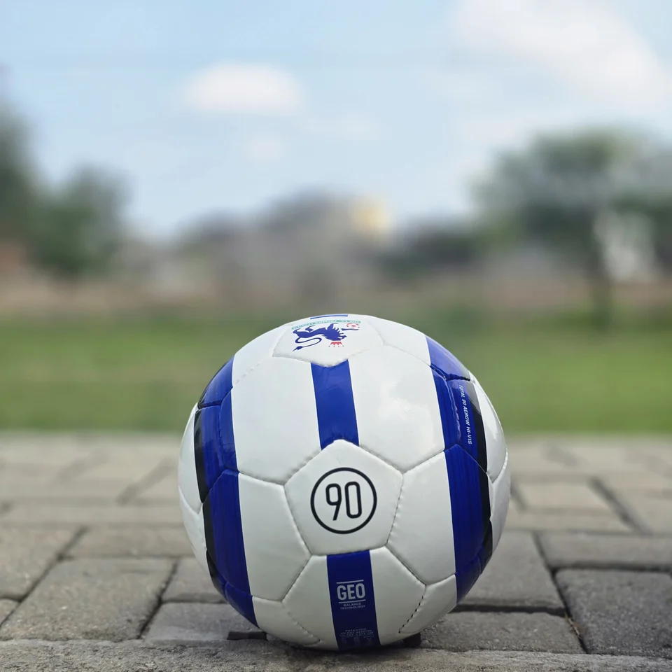 Blue Purple Tricolor-Style Hand-Stitched Football side view - white handmade football with blue and purple panel graphics and visible tricolor-style printed text