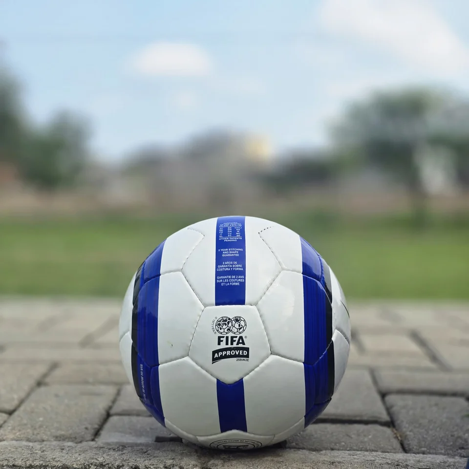 Blue Purple Tricolor-Style Hand-Stitched Football side view - white handmade football with blue and purple panel graphics and visible tricolor-style printed text