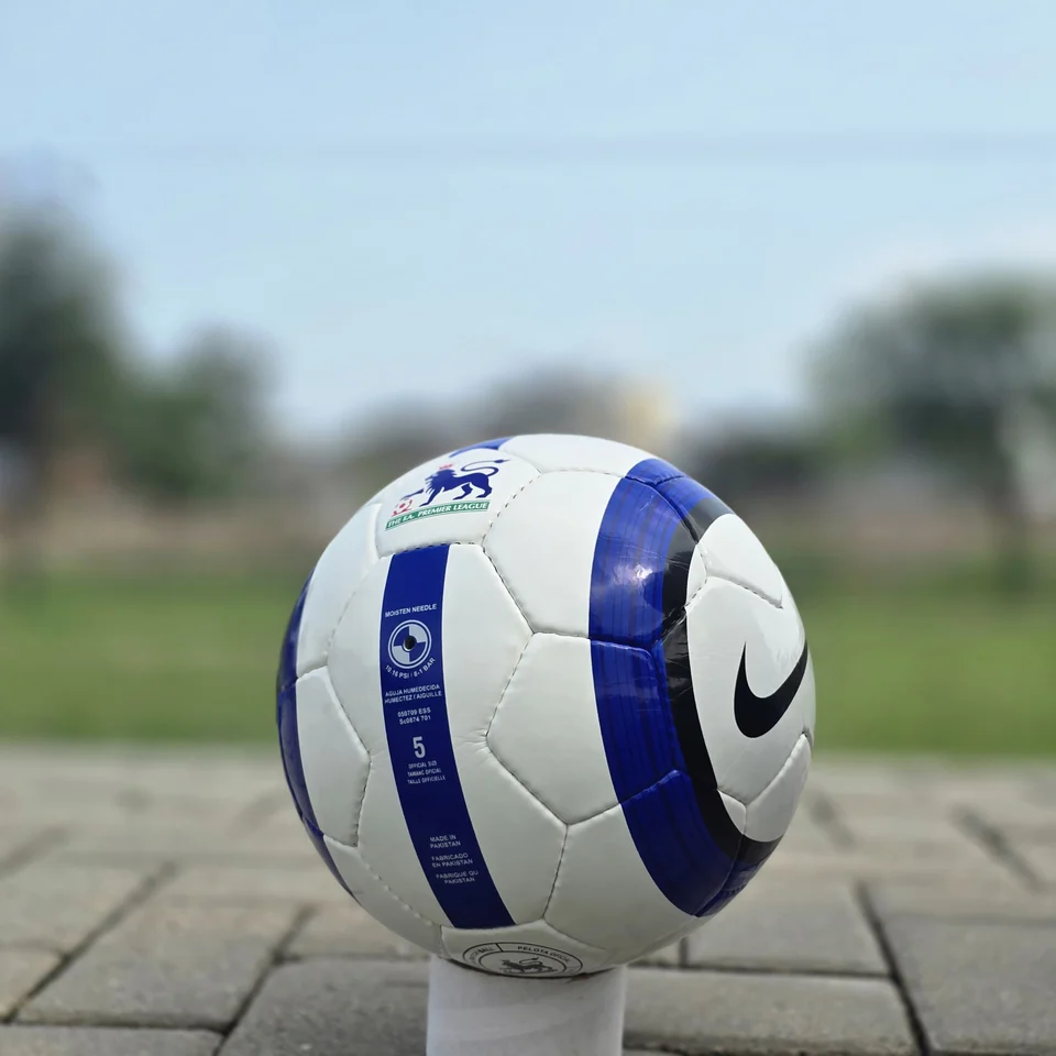 Blue Stripe Custom Panel Hand-Stitched Football alternate front angle - white handmade football with blue vertical stripes and a small printed badge detail