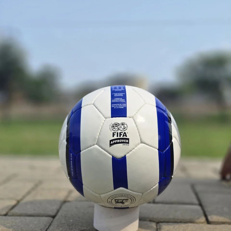 Blue Stripe Custom Panel Hand-Stitched Football design detail - white handmade football with blue vertical stripes and a small printed badge detail