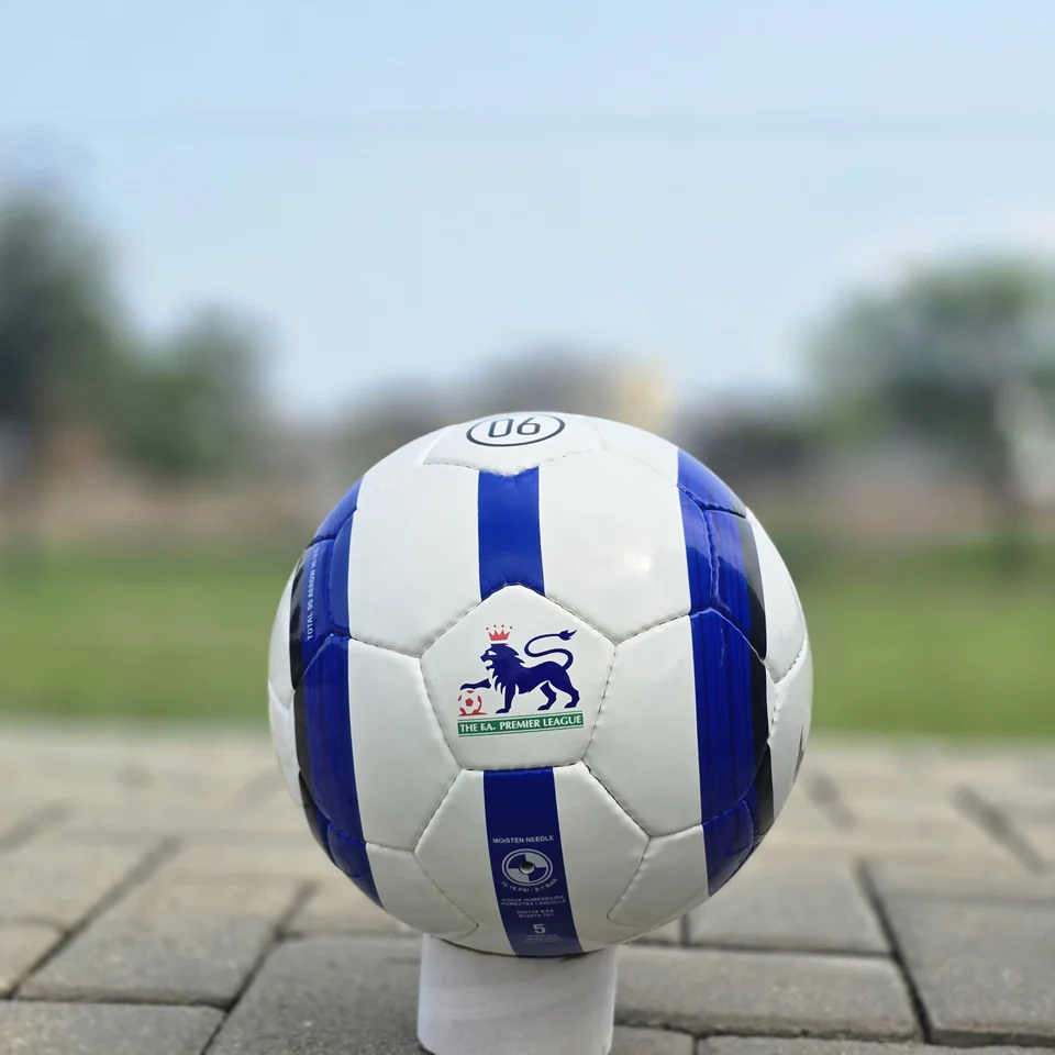 Blue Stripe Custom Panel Hand-Stitched Football front view - white handmade football with blue vertical stripes and a small printed badge detail