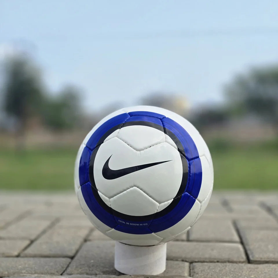 Blue Stripe Custom Panel Hand-Stitched Football side view - white handmade football with blue vertical stripes and a small printed badge detail