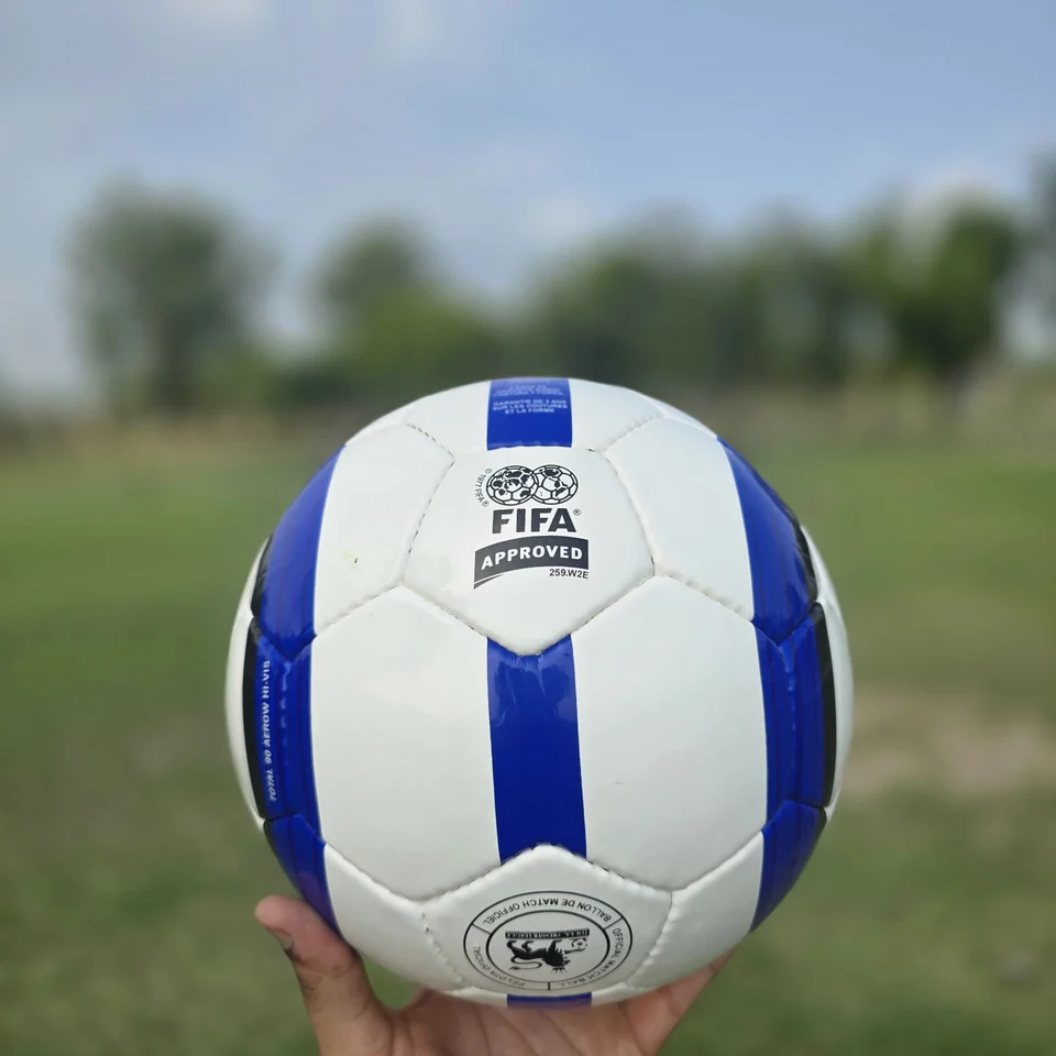 Blue Stripe GEO Style Hand-Stitched Football front view - white handmade football with blue vertical stripes and visible GEO-style printed panel text