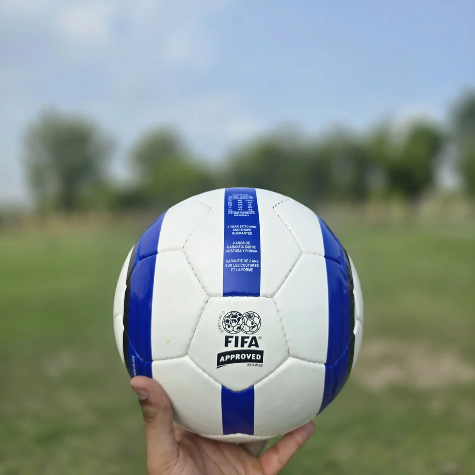 Blue Stripe GEO Style Hand-Stitched Football side view - white handmade football with blue vertical stripes and visible GEO-style printed panel text