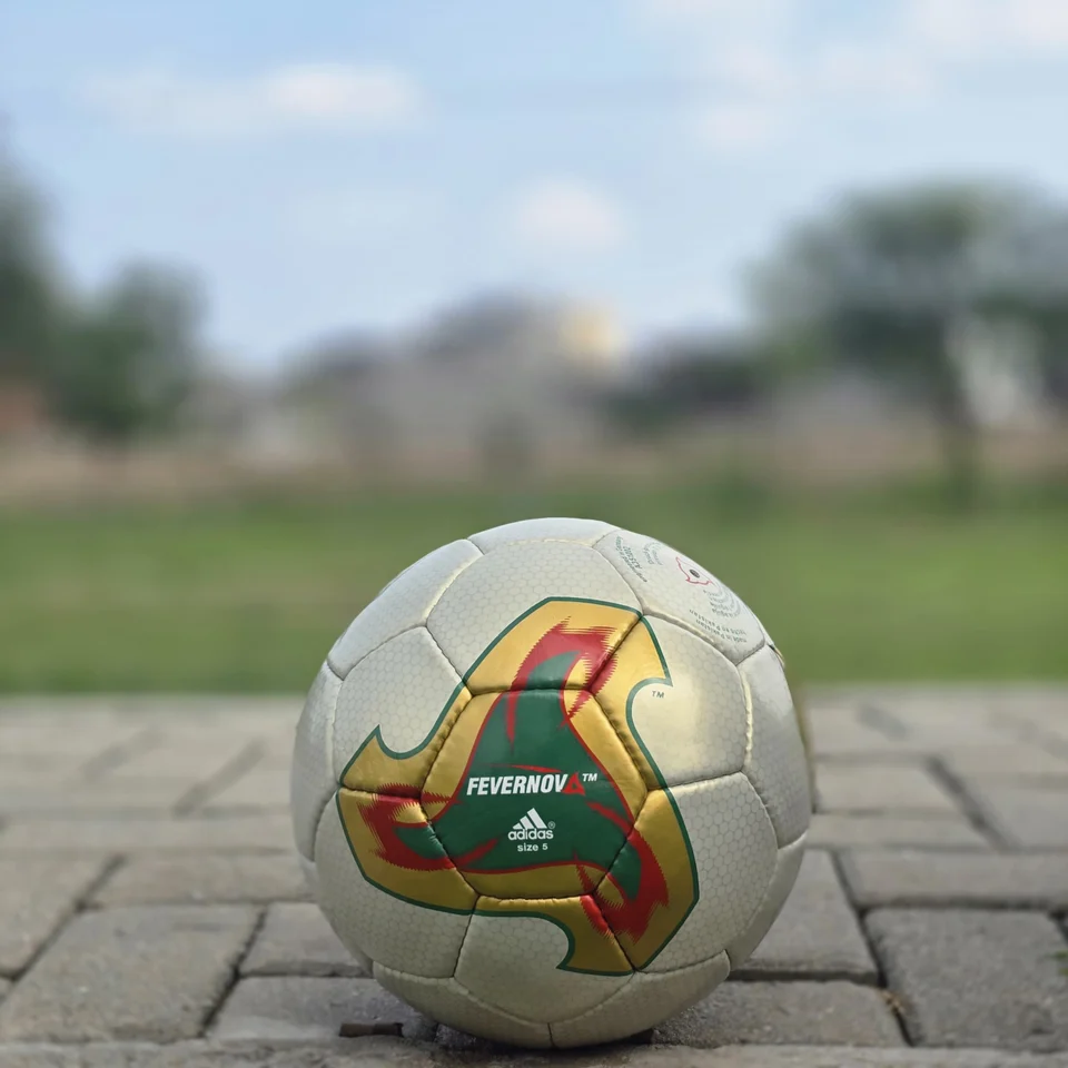 Cream Geometric Panel Hand-Stitched Football alternate front angle - cream handmade football with tan, orange, and green geometric panel artwork