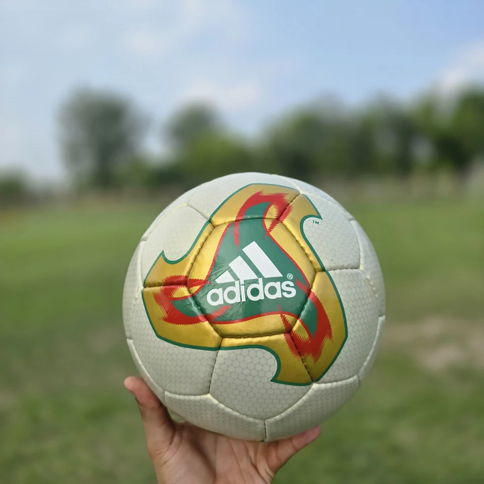 Cream Orange Geometric Hand-Stitched Football front view - cream handmade football with orange, tan, and green geometric graphics