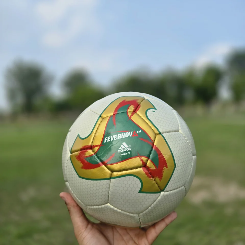Cream Orange Geometric Hand-Stitched Football side view - cream handmade football with orange, tan, and green geometric graphics