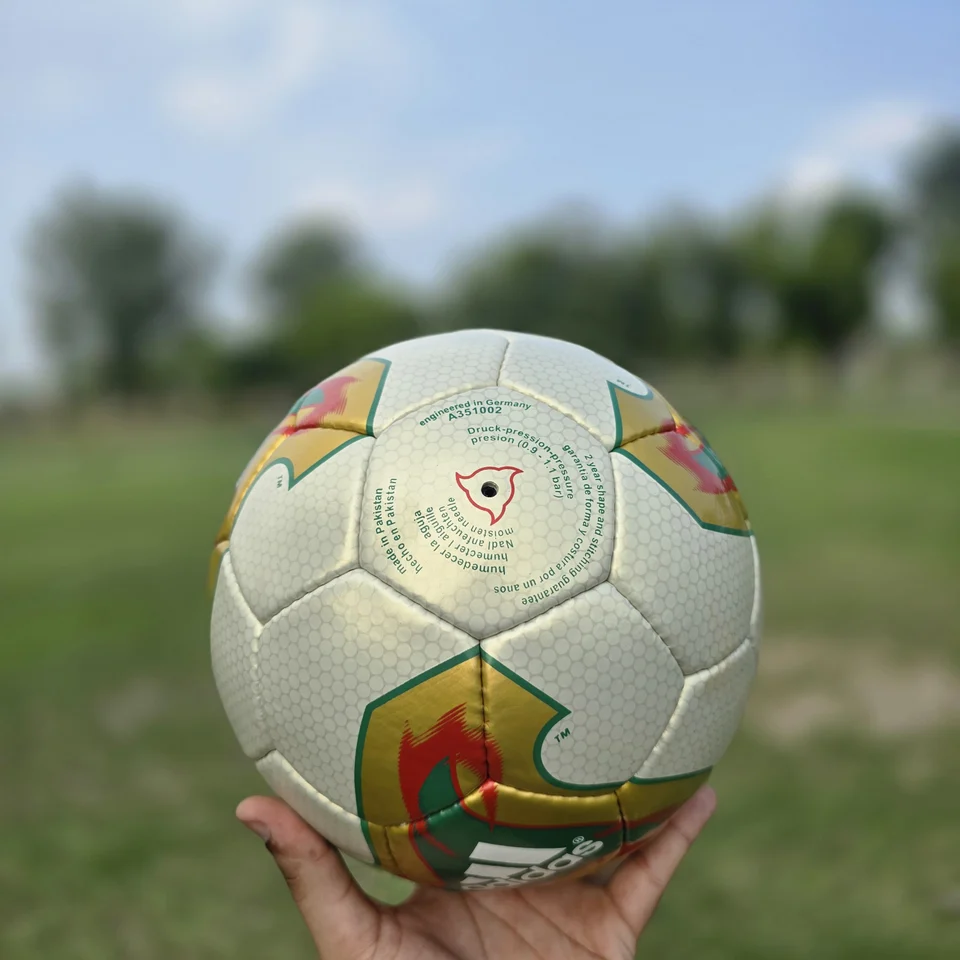 Cream Orange Geometric Hand-Stitched Football side view - cream handmade football with orange, tan, and green geometric graphics