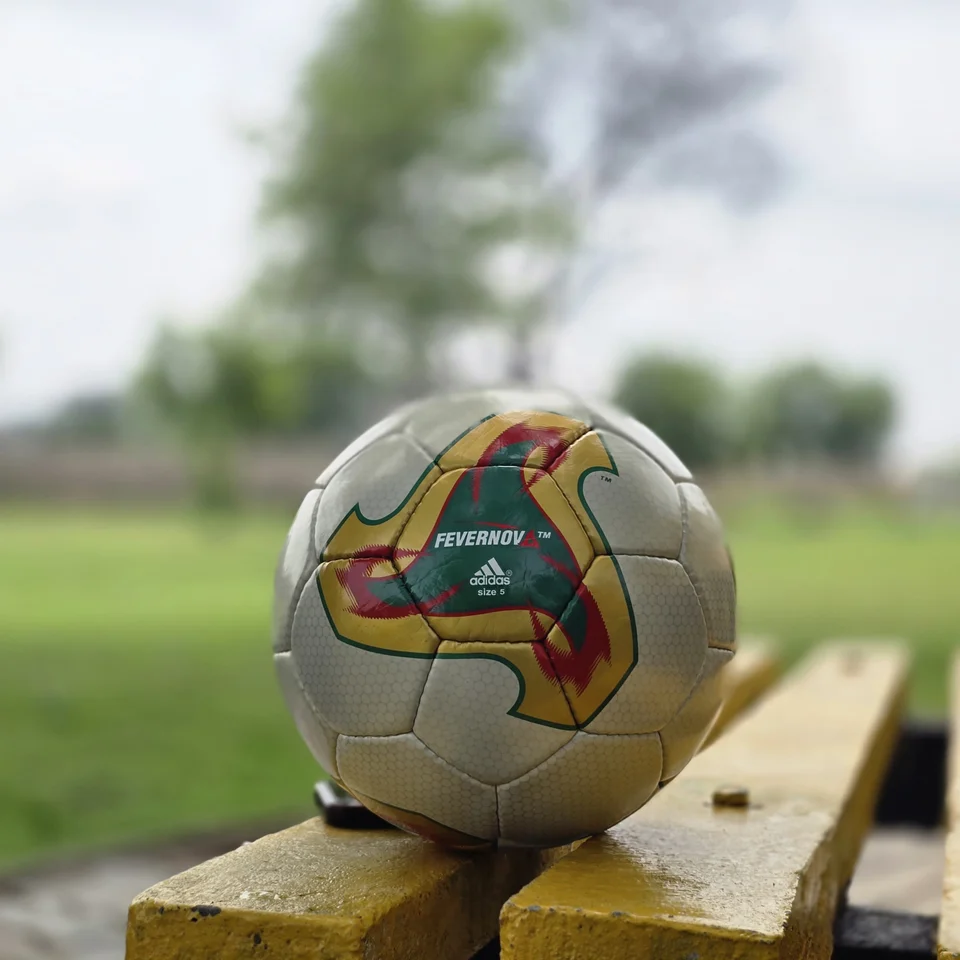 Cream Tan Graphic Hand-Stitched Football side view - cream handmade football with tan, orange, and green printed geometric panel accents
