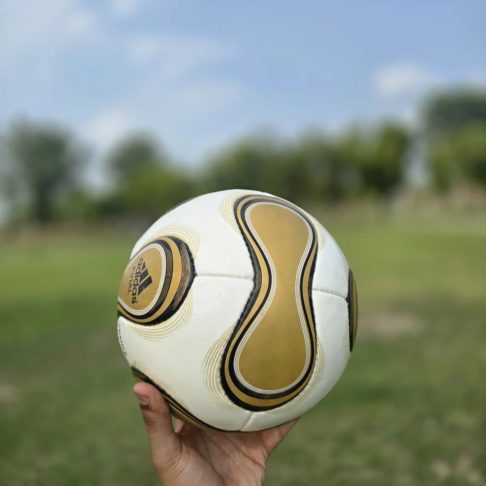 Gold Swirl Hand-Stitched Football design detail - white handmade football with gold and black swirl panel artwork