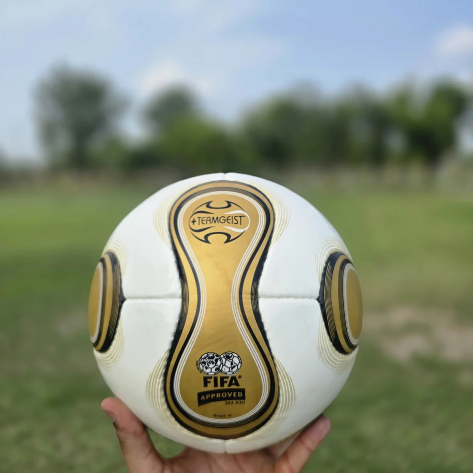 Gold Swirl Hand-Stitched Football front view - white handmade football with gold and black swirl panel artwork