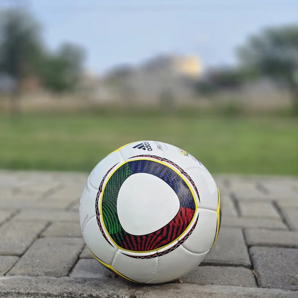 Green Yellow Accent Hand-Stitched Football back view - white handmade football with green, yellow, black, and red curved accent panels
