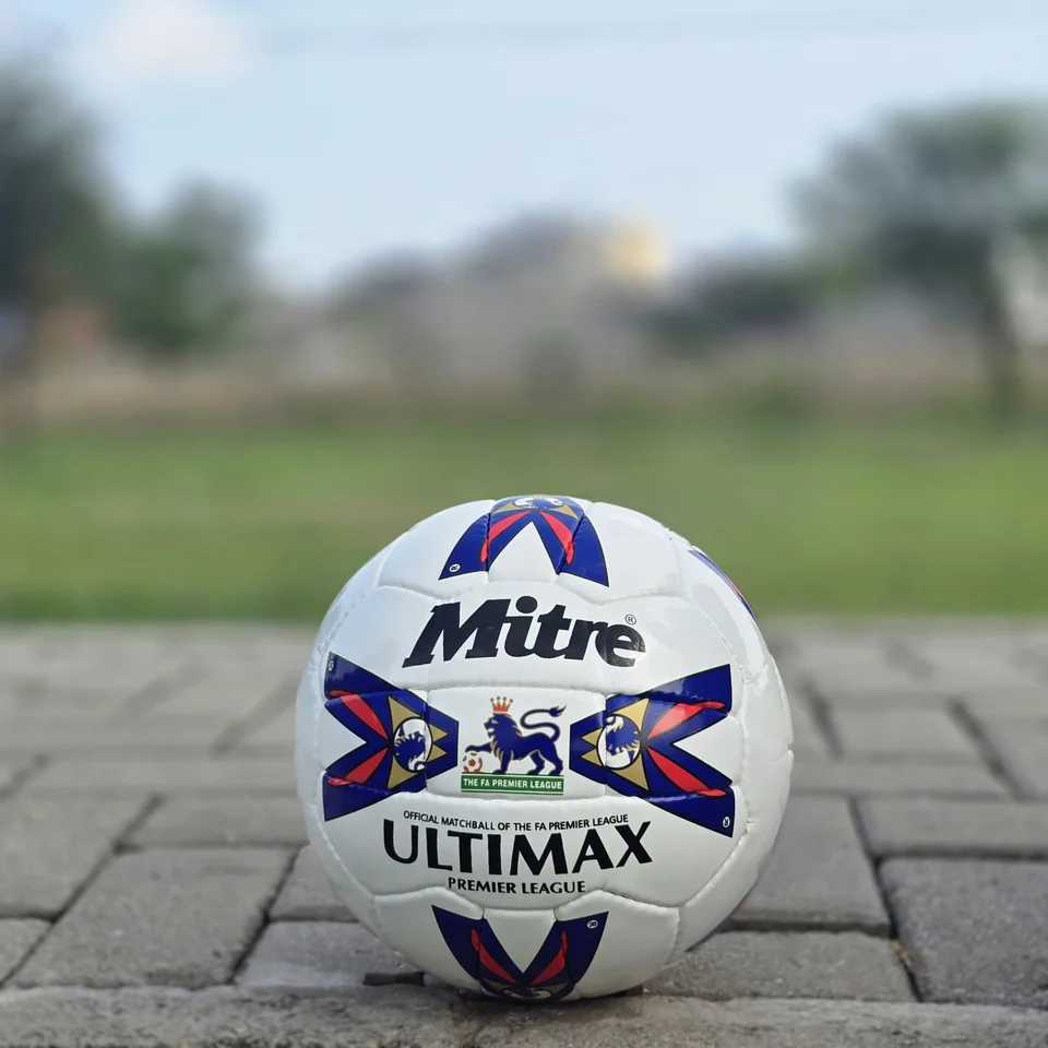 Red & Blue Arrow Panel Hand-Stitched Football design detail - white handmade football with red and blue arrow-style panel graphics
