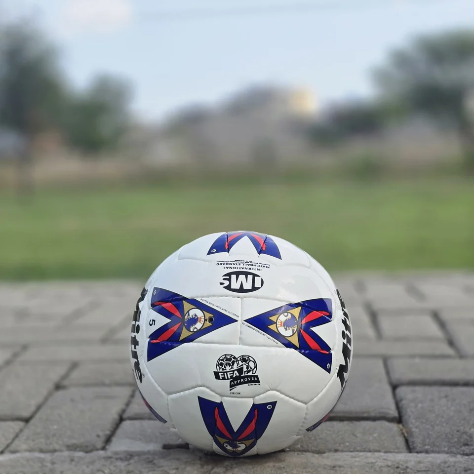 Red & Blue Arrow Panel Hand-Stitched Football front view - white handmade football with red and blue arrow-style panel graphics