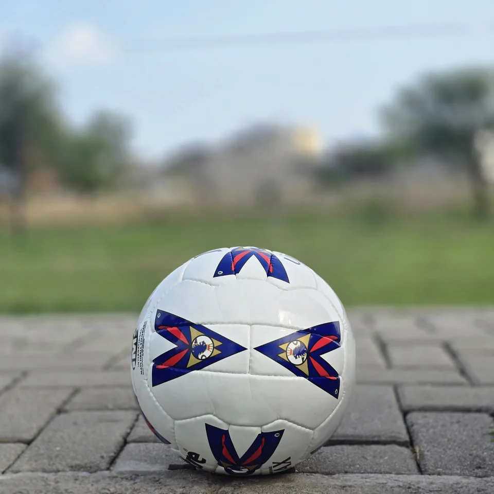 Red & Blue Arrow Panel Hand-Stitched Football side view - white handmade football with red and blue arrow-style panel graphics