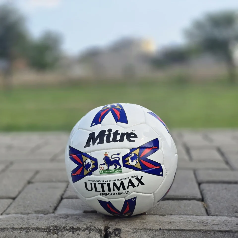 Red & Blue Arrow Panel Hand-Stitched Football side view - white handmade football with red and blue arrow-style panel graphics
