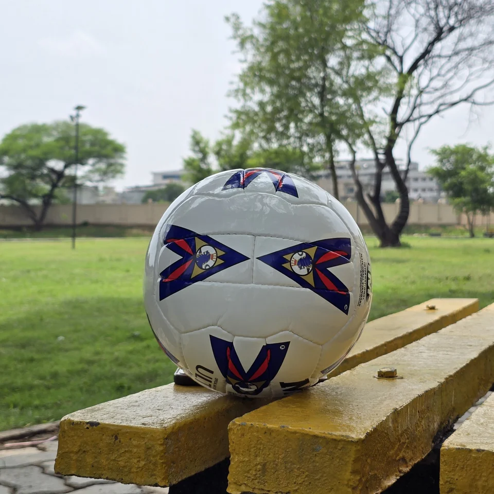 Red Blue Arrow Match-Style Hand-Stitched Football alternate front angle - white handmade football with red and blue arrow panel artwork photographed on a wooden bench