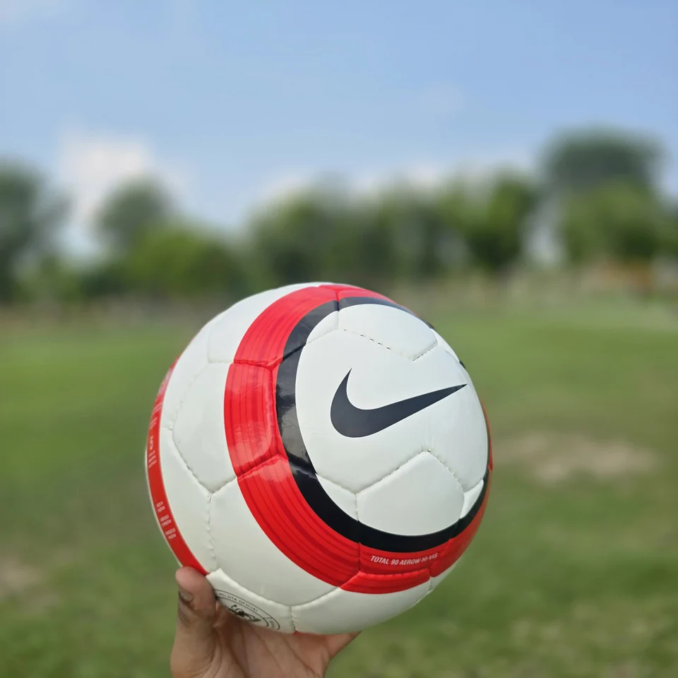 Red Stripe Badge Hand-Stitched Football back view - white handmade football with red vertical stripe panels and small badge-style artwork