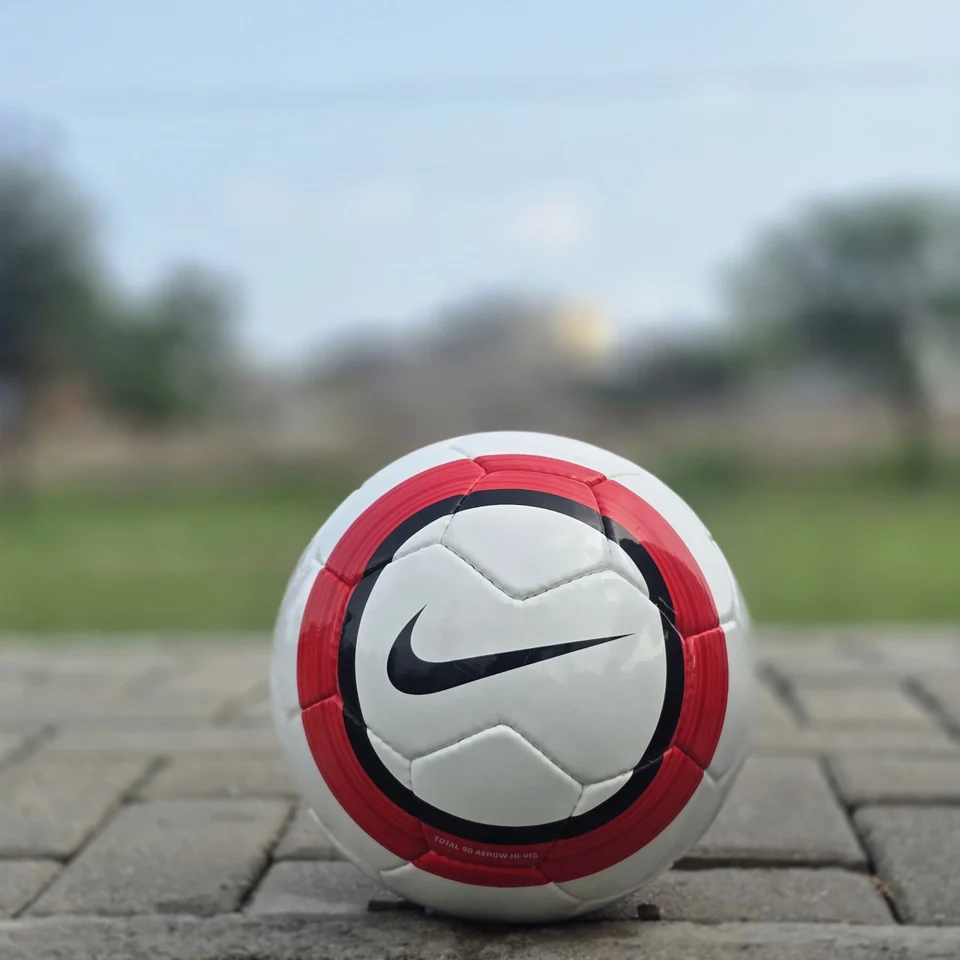 Red Stripe Custom Logo Hand-Stitched Football back view - white handmade football with red vertical stripes and a small lion-style graphic badge