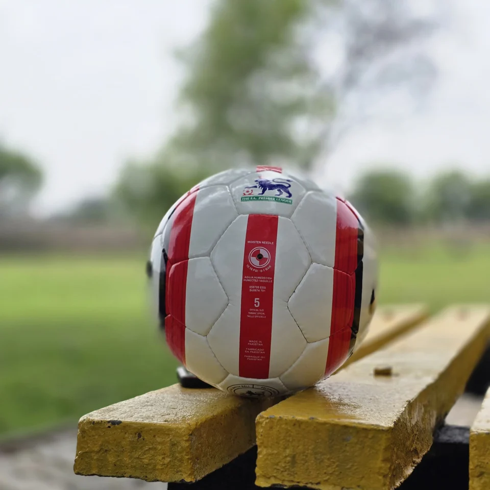 Red Stripe Lion Graphic Hand-Stitched Football alternate front angle - white handmade football with red vertical stripes and a small lion-style printed graphic