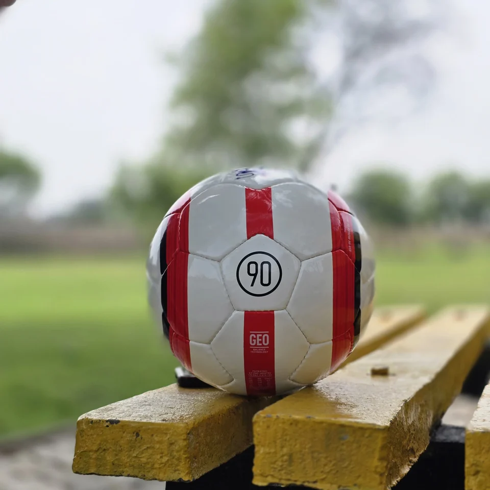 Red Stripe Lion Graphic Hand-Stitched Football back view - white handmade football with red vertical stripes and a small lion-style printed graphic