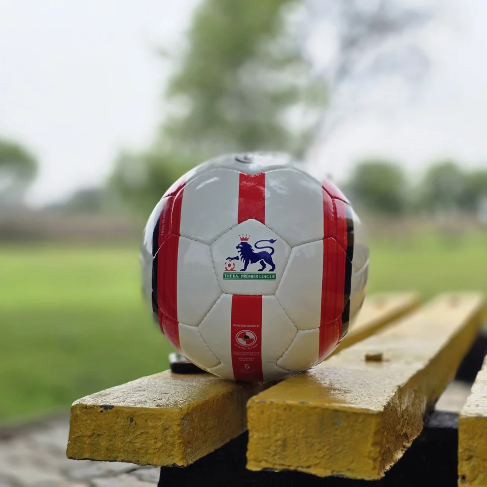 Red Stripe Lion Graphic Hand-Stitched Football front view - white handmade football with red vertical stripes and a small lion-style printed graphic