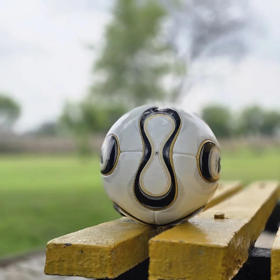 White Black Gold Swirl Hand-Stitched Football side view - white handmade football with black and gold swirl panel artwork