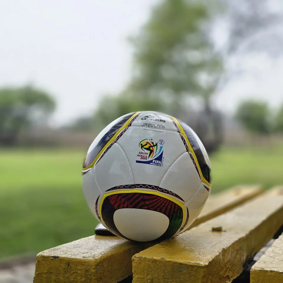 White Black Yellow Accent Hand-Stitched Football alternate front angle - white handmade football with black, yellow, green, and red accent panel graphics