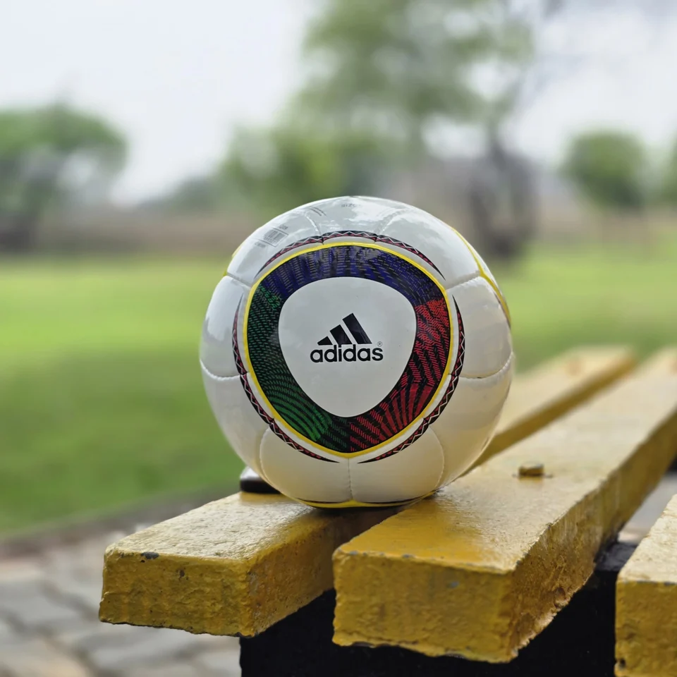 White Black Yellow Accent Hand-Stitched Football supporting view 10 - white handmade football with black, yellow, green, and red accent panel graphics