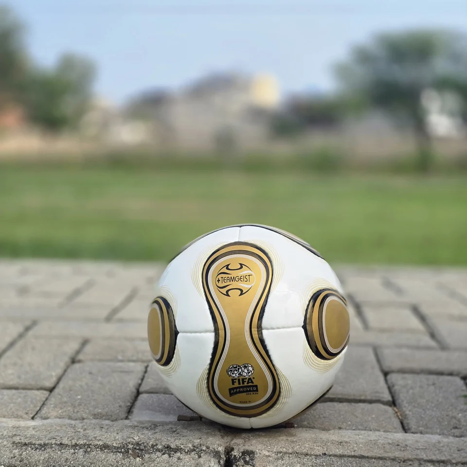 White Gold Swirl Hand-Stitched Football alternate front angle - white handmade football with metallic gold and black flowing swirl graphics