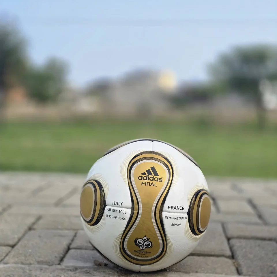 White Gold Swirl Hand-Stitched Football front view - white handmade football with metallic gold and black flowing swirl graphics