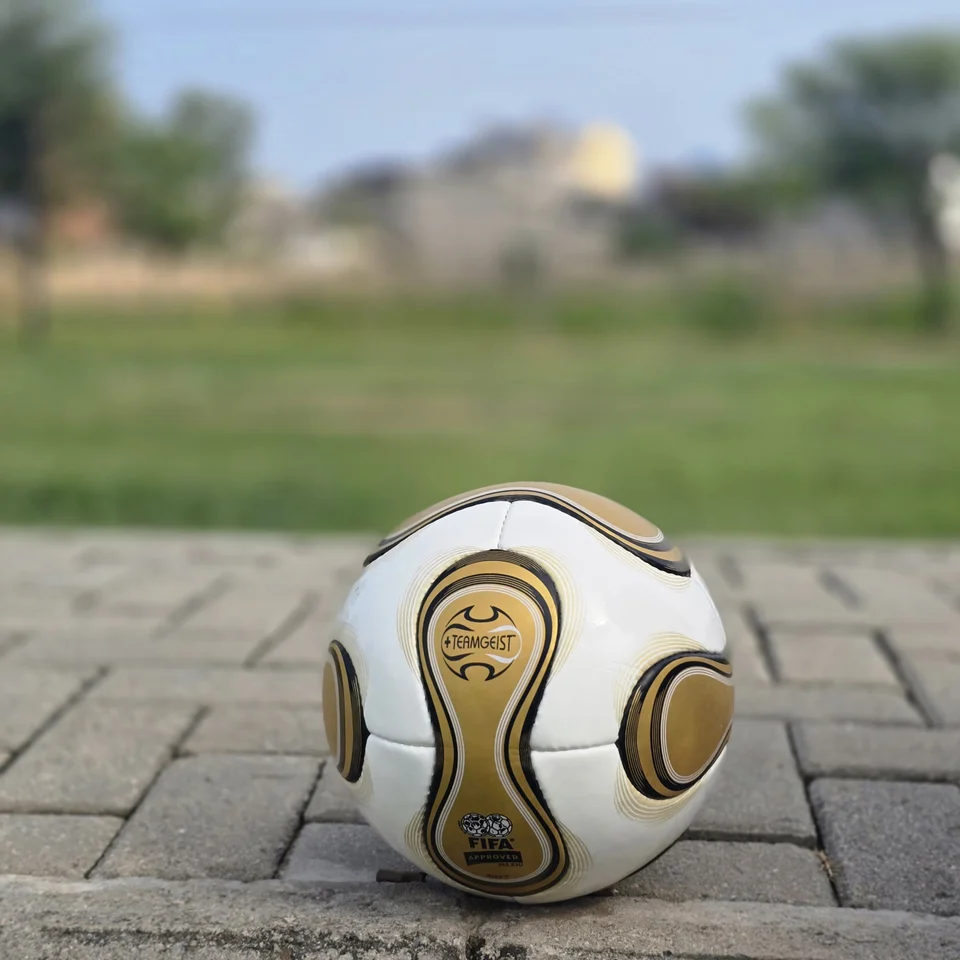 White Gold Swirl Hand-Stitched Football side view - white handmade football with metallic gold and black flowing swirl graphics