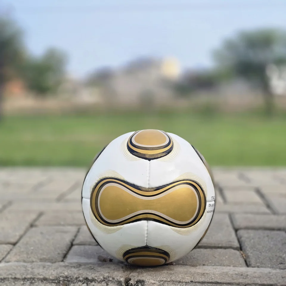 White Gold Swirl Hand-Stitched Football side view - white handmade football with metallic gold and black flowing swirl graphics