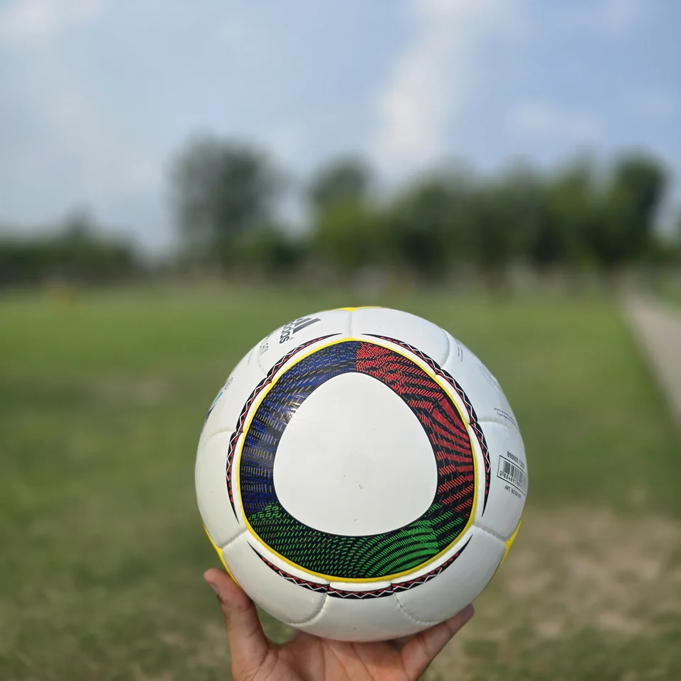 White Green Yellow Panel Hand-Stitched Football design detail - white handmade football with green, yellow, and black panel accents