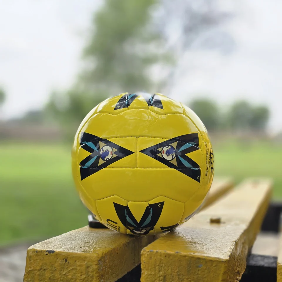 Yellow Black Crest Panel Hand-Stitched Football alternate front angle - yellow handmade football with black graphic panels and a small crest-style mark
