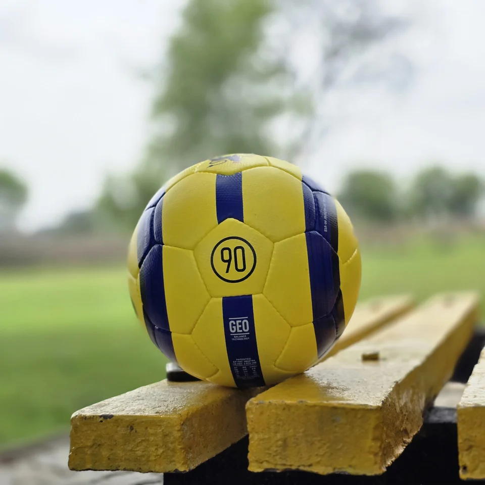 Yellow Black Crest Panel Hand-Stitched Football design detail - yellow handmade football with black graphic panels and a small crest-style mark