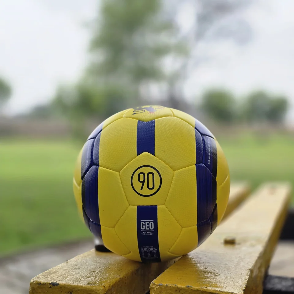 Yellow Black Crest Panel Hand-Stitched Football side view - yellow handmade football with black graphic panels and a small crest-style mark