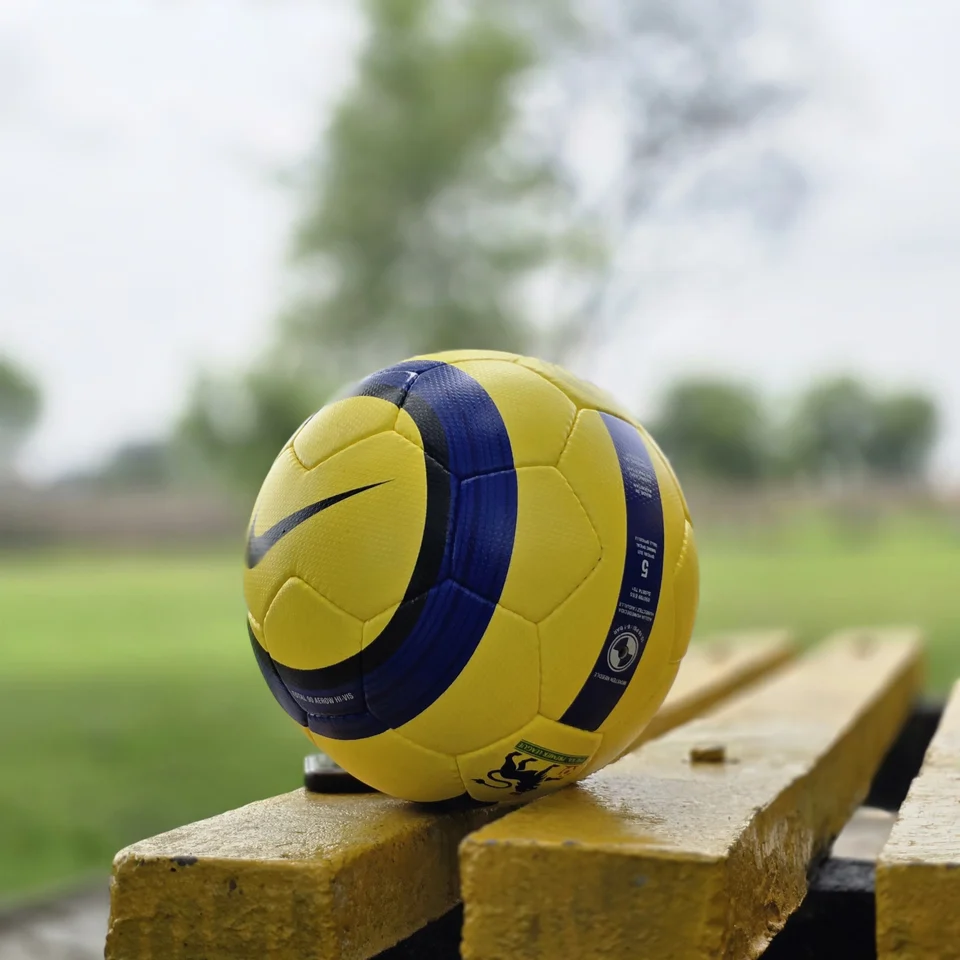 Yellow Ultimax-Style Printed Hand-Stitched Football alternate front angle - yellow handmade football with black angular graphics and visible Ultimax-style printed text